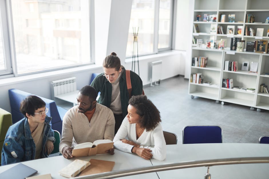 A diverse group of students collaborating on a project in a modern library setting.